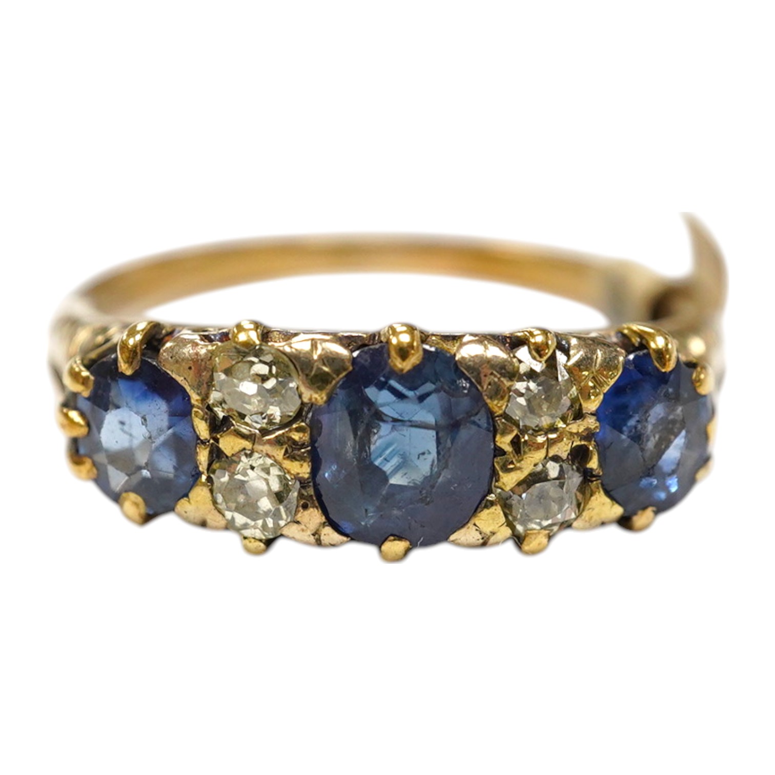 A yellow metal and three stone sapphire and four stone diamond set half hoop ring, size P/Q, gross weight 3.3 grams. Condition - poor to fair